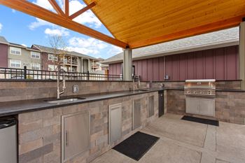 A patio with a stone wall and a wooden roof.